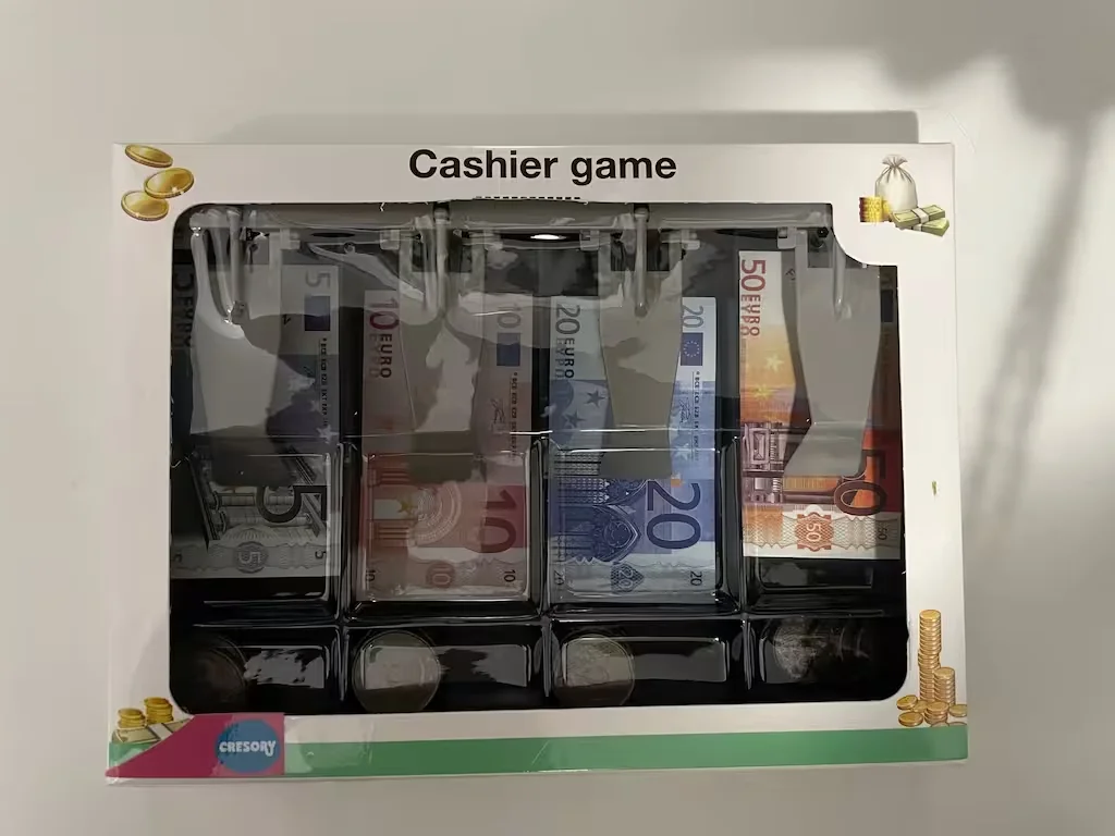 Caja del juego Cashier game con billetes y monedas de juguete en compartimentos