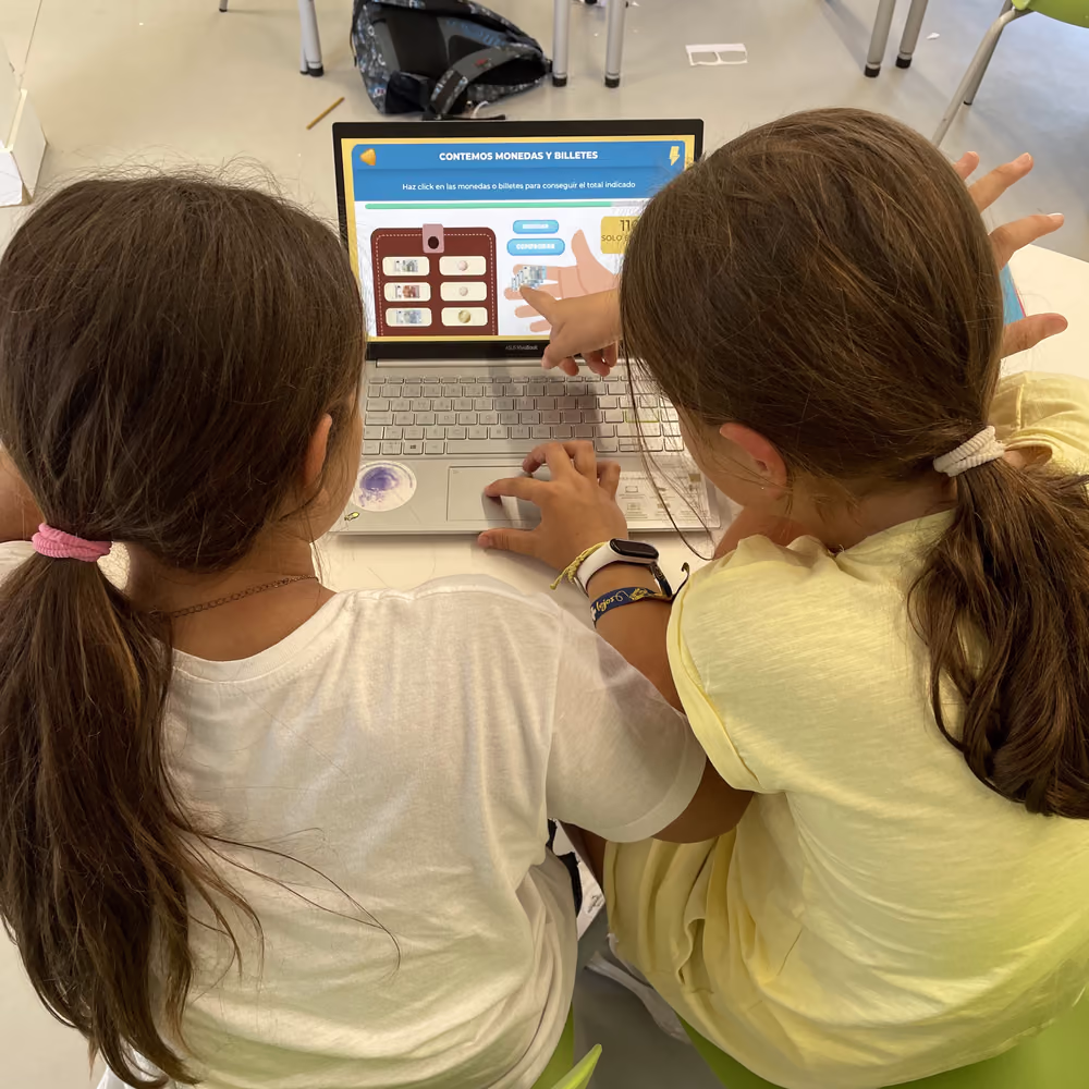Dos niñas jugando juntas a la plataforma de Cresory en un portátil durante un taller